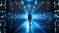 A successful Data Center IT Specialist using a laptop computer. A server farm cloud computing facility with a system
