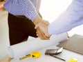 Successful deal, Female architect shaking hands with client in construction site after confirm blueprint for renovate building Royalty Free Stock Photo