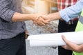 Successful deal, Female architect shaking hands with client in construction site after confirm blueprint for renovate building Royalty Free Stock Photo