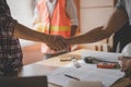 Successful deal, male architect shaking hands with client in construction site after confirm blueprint for renovate building Royalty Free Stock Photo