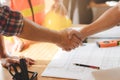 Successful deal, male architect shaking hands with client in construction site after confirm blueprint for renovate building Royalty Free Stock Photo