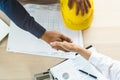 Successful deal, male architect shaking hands with client in construction site after confirm blueprint for renovate building Royalty Free Stock Photo