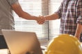 Successful deal, male architect shaking hands with client in construction site after confirm blueprint for renovate building Royalty Free Stock Photo