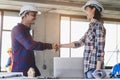 Successful deal, male architect shaking hands with client in construction site after confirm blueprint for renovate building Royalty Free Stock Photo