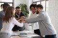 Successful diverse employees stacking hands, engaged in team building Royalty Free Stock Photo