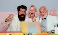 Successful entrepreneurs and business people. Funny excited group of businesspeople working on a laptop at a table in an Royalty Free Stock Photo