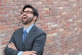 Successful excited business man happy smile looking up to empty copy space, handsome young businessman surprise with arms crossed