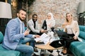 Successful excited multi-ethnic group of business people sitting together in office around the table with papers and Royalty Free Stock Photo