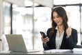 Successful and exciting businesswoman Young woman excited to winner on her smartphone at work Royalty Free Stock Photo