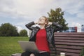 Successful female freelance designer working outside, stretching hands, tired, break