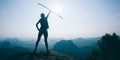 female hiker cheering on mountain top cliff edge Royalty Free Stock Photo