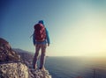 hiker stand on sunrise seaside mountain cliff edge