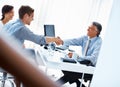 Successful financial plans. Mature male advisor shaking hands with handsome man and woman in office. Royalty Free Stock Photo