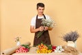 Successful floral business. Beautiful bouquet arrangement. Confident flower seller. Smiling man florist making bouquet in flower Royalty Free Stock Photo