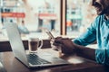 Successful freelancer with laptop is drinking Latte in coffee shop.