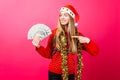 A successful girl in a red sweater and Santa hat holds the money Royalty Free Stock Photo