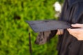 Successful graduate, in academic dresses, holding a graduation c