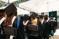 Successful graduates in academic dresses, at graduation, sitting Royalty Free Stock Photo