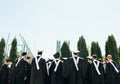 Successful graduates in academic dresses, toss up their hats, go Royalty Free Stock Photo