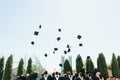 Successful graduates in academic dresses, toss up their hats, go Royalty Free Stock Photo