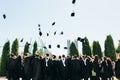 Successful graduates in academic dresses, toss up their hats, go Royalty Free Stock Photo