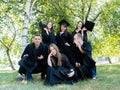Successful graduation from university, education concept. Group of happy university graduates in black mantle looking at
