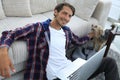 Successful guy stroking his pet sitting on the floor near the sofa Royalty Free Stock Photo