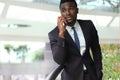 Successful handsome african american businessman talking on mobile phone in modern office. Royalty Free Stock Photo