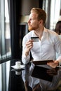 Successful handsome business man holding credit card, using digital tablet. Online shopping concept Royalty Free Stock Photo