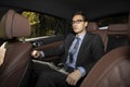 Successful handsome businessman sitting in the passenger seat in his luxury car and driving to a business meeting Royalty Free Stock Photo