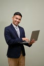 Successful Asian businessman in formal business suit holding his portable laptop, using laptop Royalty Free Stock Photo