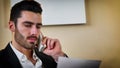 Smiling handsome young businessman at desk on phone Royalty Free Stock Photo