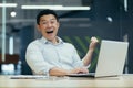 Successful and happy Asian man, businessman, shows yes with his hand. Made a contract. Won money. Royalty Free Stock Photo