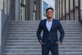 Successful happy businessman outside office posing and looking at camera african american man in business suit smiling Royalty Free Stock Photo