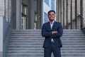 Successful happy businessman outside office posing and looking at camera african american man in business suit smiling Royalty Free Stock Photo