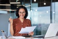 Successful and happy businesswoman satisfied with achievement results, smiling and looking at camera holding documents Royalty Free Stock Photo