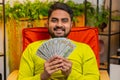 Successful happy rich Indian man counting money, celebrate lottery game win, holding dollars cash Royalty Free Stock Photo