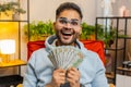 Successful happy rich Indian man counting money, celebrate lottery game win, holding dollars cash Royalty Free Stock Photo