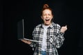 Successful happy shocked young woman with open mouth and closed eyes holding laptop computer Royalty Free Stock Photo