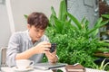 Successful hipster guy waiting friend in coffee shop while checking photos at vintage camera during free time Royalty Free Stock Photo