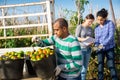 Gardener loading buckets with picked tomatoes in truck