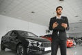 Successful indian businessman in a car dealership - sale of vehicles to customers. Royalty Free Stock Photo