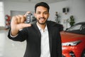 Successful indian businessman in a car dealership - sale of vehicles to customers. Royalty Free Stock Photo