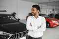 Successful indian businessman in a car dealership - sale of vehicles to customers. Royalty Free Stock Photo