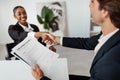 Successful job interview. Hired female candidate shaking hands with the HR team recruiter, signing employment contract Royalty Free Stock Photo