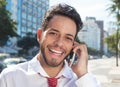 Successful latin businessman at phone in the city