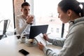 Successful leader and business owner leads an informal business meeting in a cafe.Young woman takes notes on a notepad