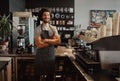 Successful male business owner behind the counter of a coffee shop with folded hands smiling looking at camera Royalty Free Stock Photo