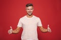 Successful man 30s in striped t-shirt gesturing and demonstratin Royalty Free Stock Photo