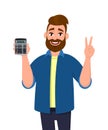 Successful man showing or holding digital calculator device in hand and gesturing, making victory, V, peace or two sign. Royalty Free Stock Photo